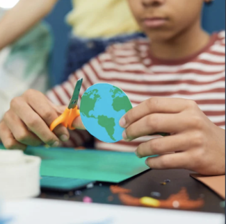 Kind bastelt mit Schere